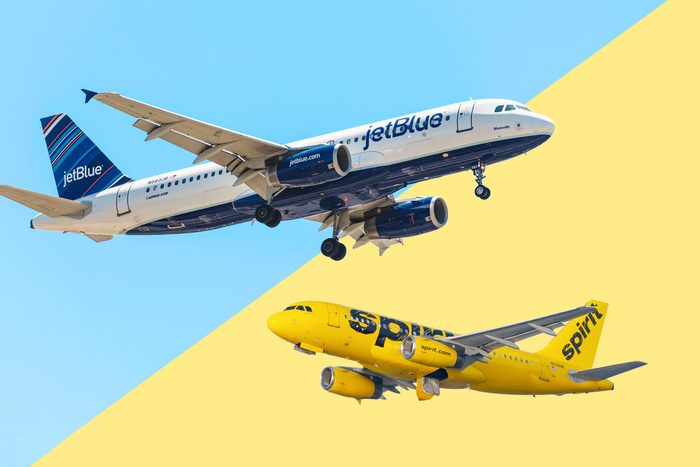 Jetblue plane over a spirit airlines plane with a split blue and yellow background