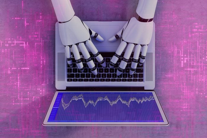above view of Robot hands typing on a laptop with a futuristic pink electrical board pattern overlapping the entire image