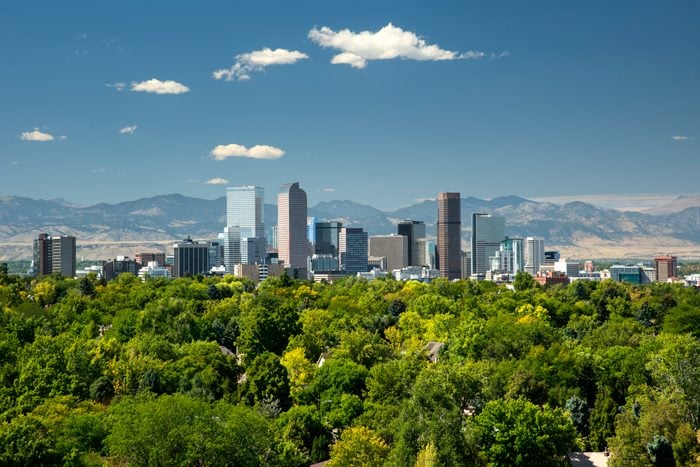 The towering high rises of Denver's downtown sit between the Front Range of the Rocky Mountains to the west and the tree lined neighborhoods and parks of the city to the east.