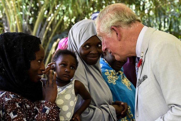 Britain's Prince Charles discusses with a mother at the Sarius Palmetum, Abuja Botanical Garden, on the third day of his visit to Nigeria