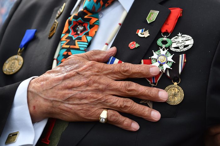 close up of a native American Indian veteran hand, Charles Shay listens to the national anthem as he takes part in a ceremony on Omaha Beach in Saint-Laurent-sur-Mer, western France on June 5, 2019, in homage to native American Indians who took part in the DDay landings of World War II