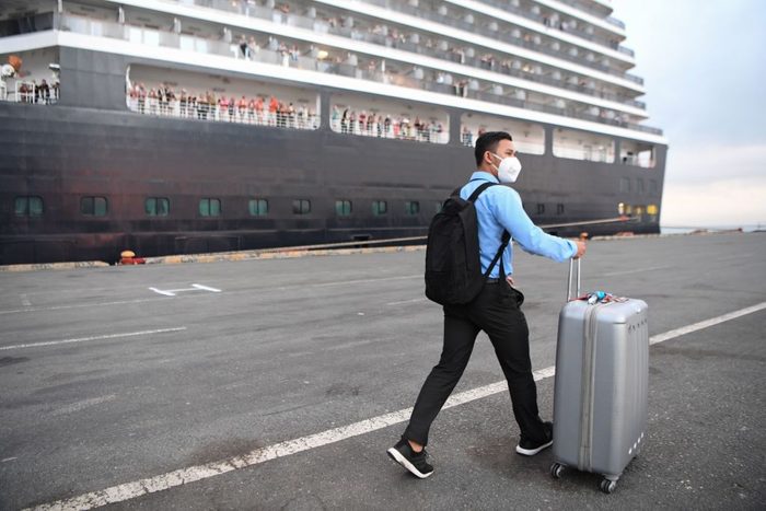 Man boarding cruise with large suitcase