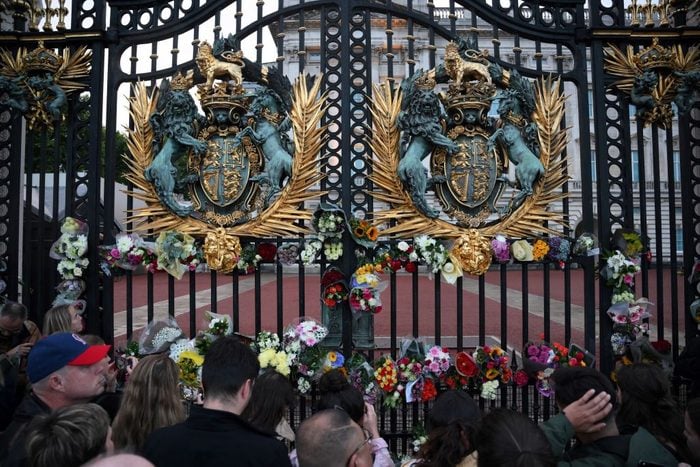 People lays flowers on the gate of Buckingham Palace in central London after it was announced that Queen Elizabeth II has died, in central London on September 8, 2022