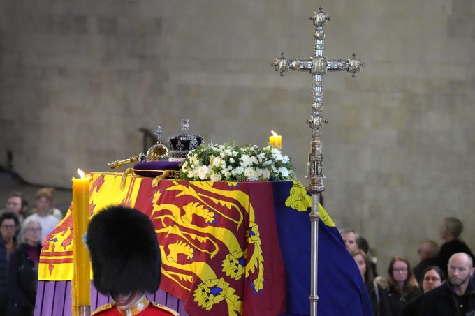 LONDON, ENGLAND - SEPTEMBER 16: The coffin of Queen Elizabeth II, draped in the Royal Standard with the Imperial State Crown and the Sovereign's orb and sceptre, lying in state on the catafalque as members of the public file past in Westminster Hall, at the Palace of Westminster, ahead of her funeral on Monday, on September 16, 2022 in London, England. Members of the public are able to pay respects to Her Majesty Queen Elizabeth II for 23 hours a day until 06:30 on September 19, 2022. Queen Elizabeth II died at Balmoral Castle in Scotland on September 8, 2022, and is succeeded by her eldest son, King Charles III. (Photo by Kirsty Wigglesworth - WPA Pool/Getty Images)