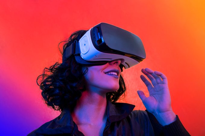 Woman Is Using Virtual Reality Viewer. Modern Woman Portrait With Trendy Look And Bright Colors.