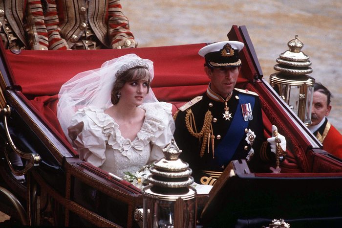 Prince Charles, Prince of Wales and Diana, Princess of Wales, wearing a wedding dress designed by David and Elizabeth Emanuel and the Spencer family Tiara, ride in an open carriage