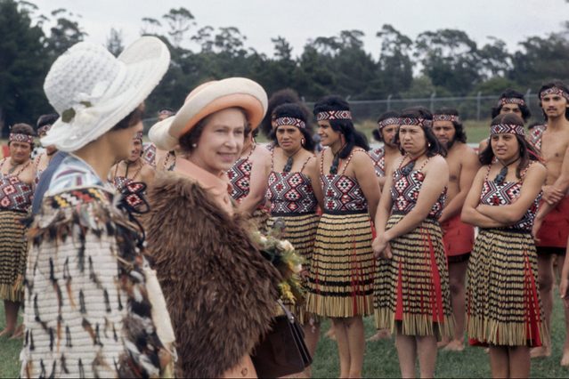 Queen Elizabeth II is greeted by a group of people in Maori dress during a trip to New Zealand, circa 1970.