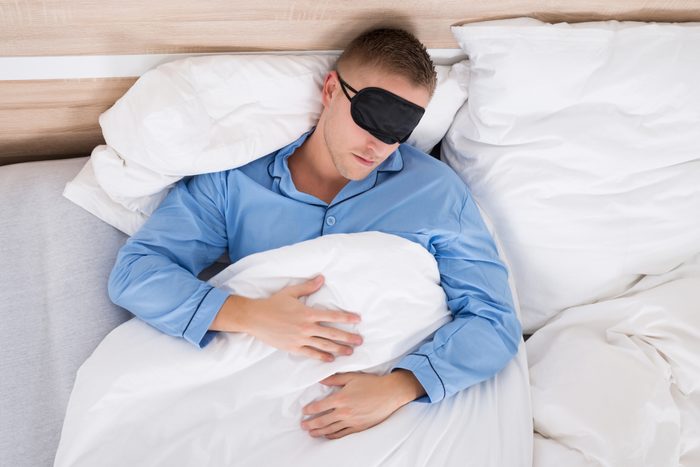 Man Sleeping On Bed Wearing Eyemask