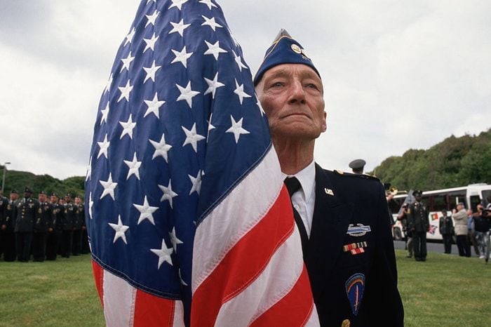 American Veteran holding a flag at 50th Anniversary of D-Day