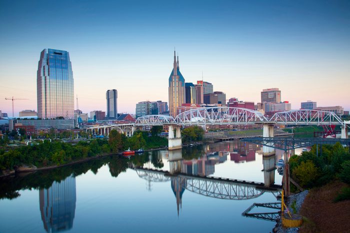 The skyline of Nashville, Tennessee reflected in the Cumberland River at sunrise.
