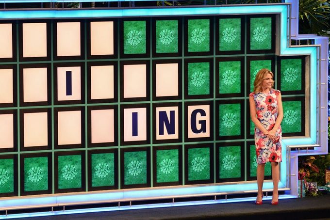 wanna white stands in front of the wheel of fortune board
