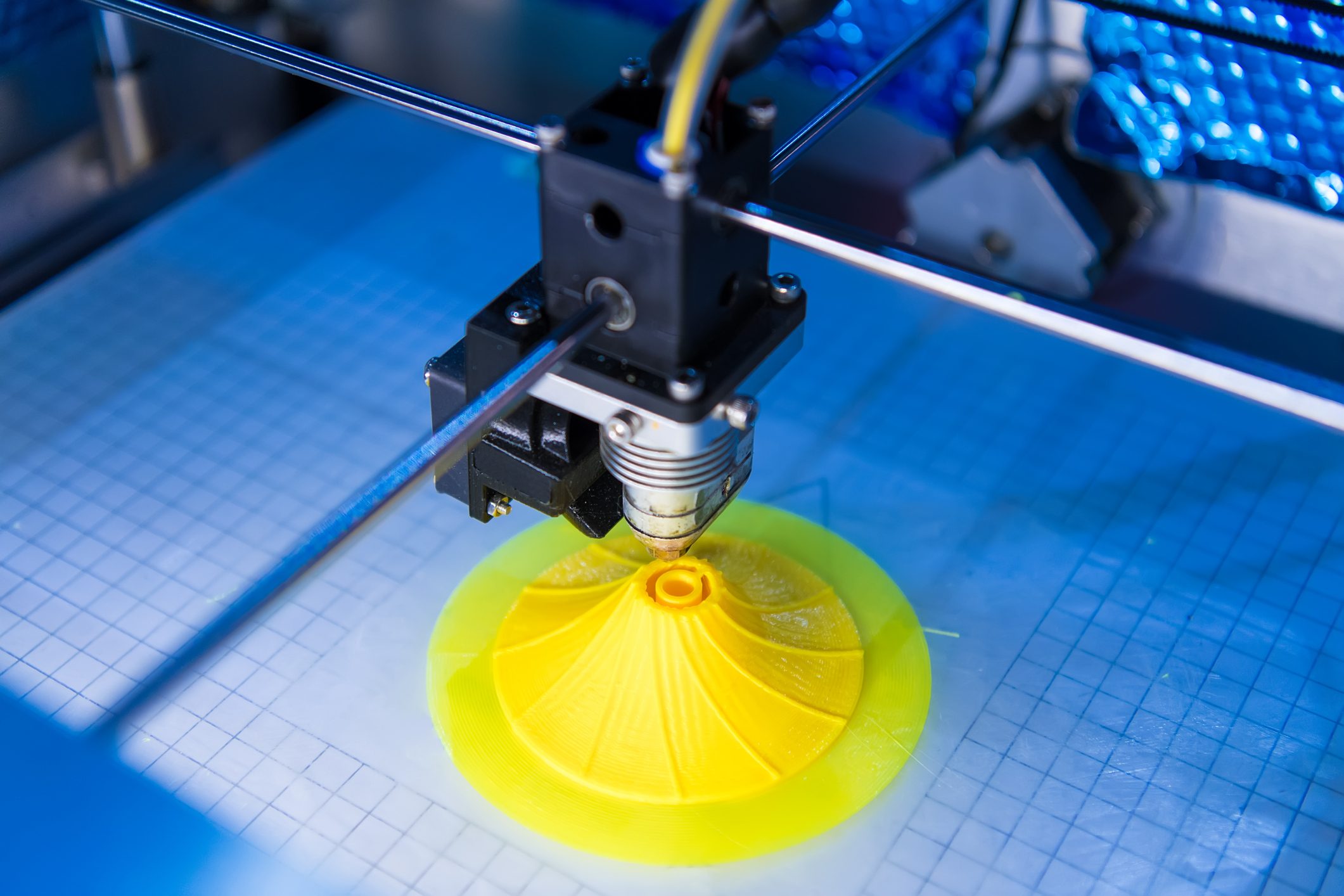 3D Printing Machine printing a yellow swirl shape