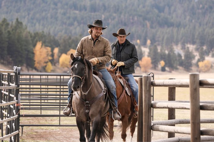 two men with cowboy hats riding on horse from the TV series, "Yellowstone"