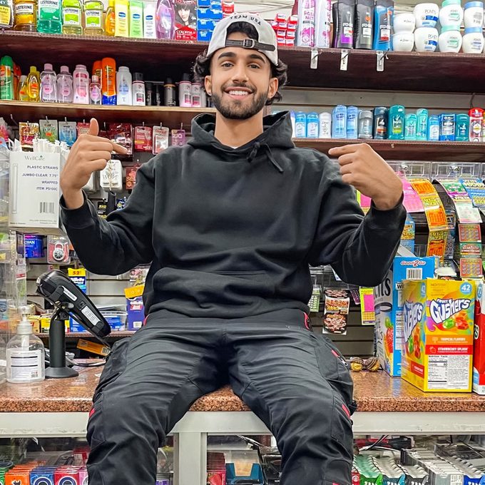 Ahmed Alwan sitting on the counter of his family's store