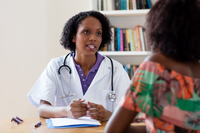 African,american,female,doctor,talking,to,patient,at,hospital