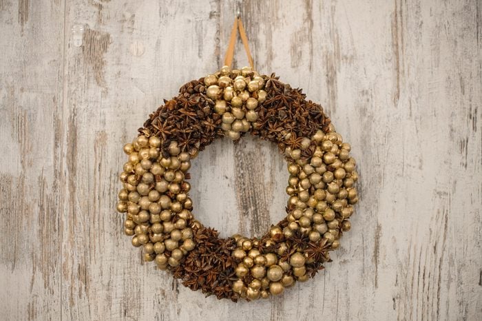 Christmas wreath of cones and gold balls on wooden background.