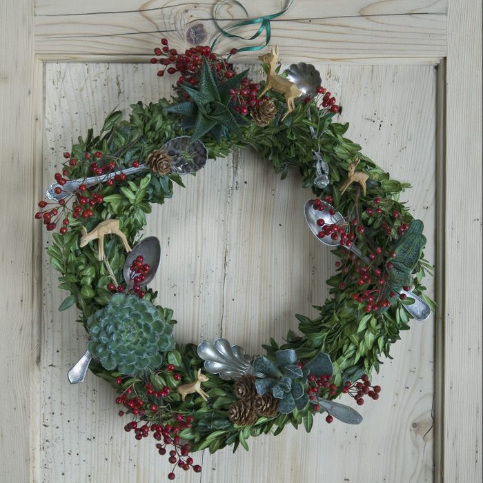 wreath with spoons hanging on wooden door
