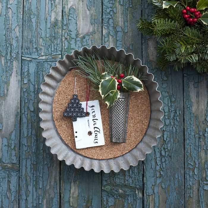 upcycled metal pie plate christmas decoration hanging on wooden wall