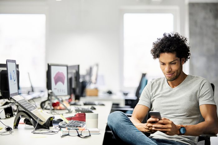 Male Entrepreneur Using Mobile Phone In Office