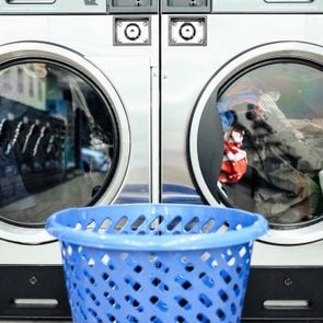 Close-Up Of Basket Against The drying machines at a laundromat