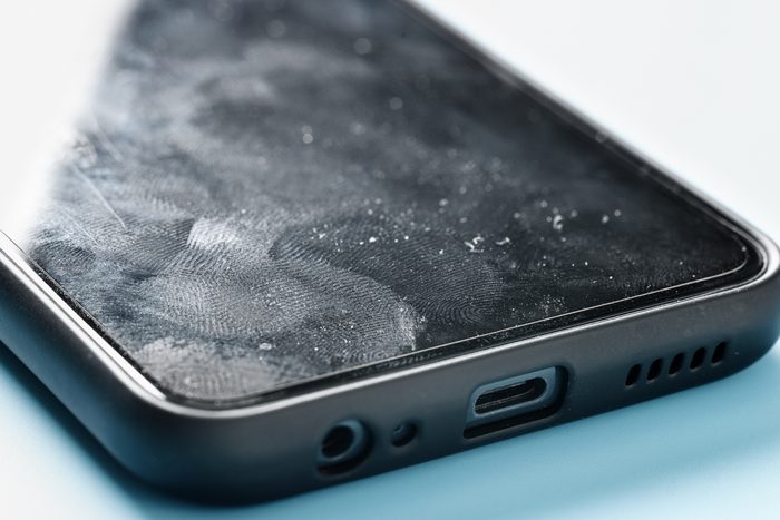 Smartphone screen surface with fingerprints and germs close up