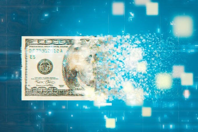a digital one hundred dollar bill pixelated and disappearing on a blue background