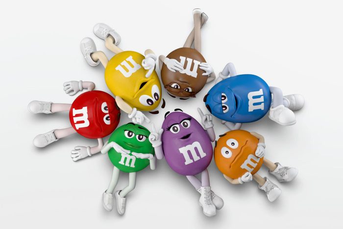 each color of the M&M characters laying in a circle with their heads touching in the middle