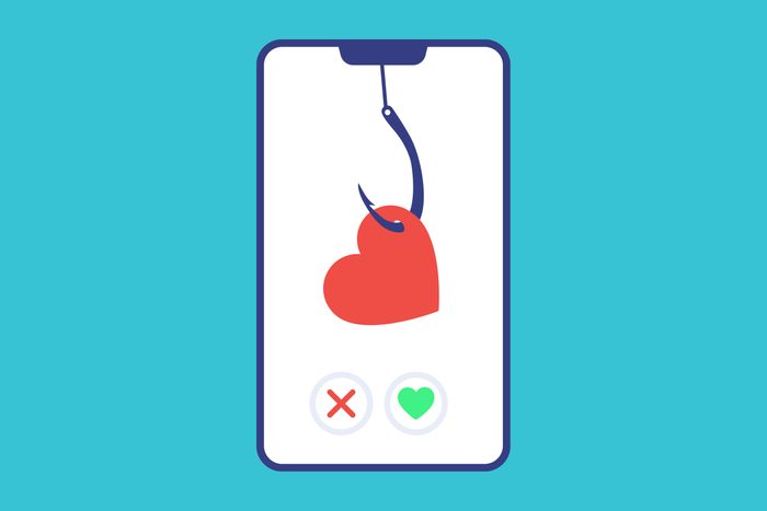 on a phone screen, heart with a fishhook to illustrate catfishing concept