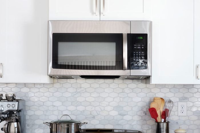Microwave above a stovetop in a modern kitchen