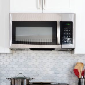 Microwave above a stovetop in a modern kitchen
