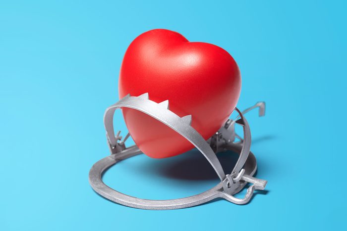 heart caugh in a bear trap on blue background