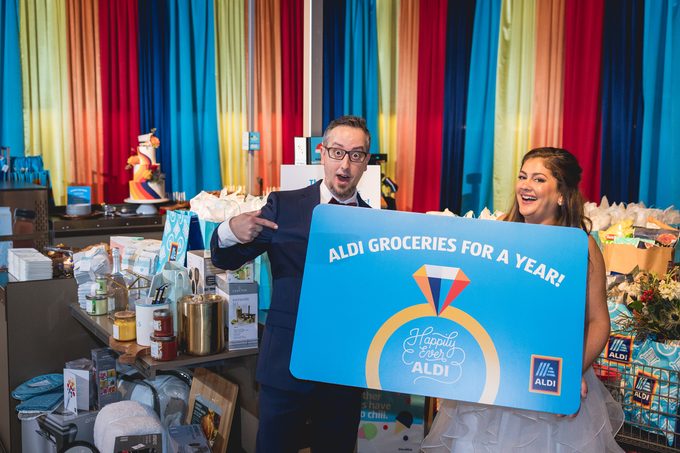 Newlywed Couple Poses with wedding gifts form winning Aldi wedding contest