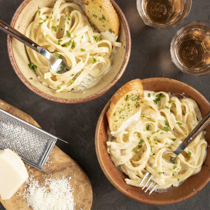 Garlic alfredo sauce with pasta in bowls