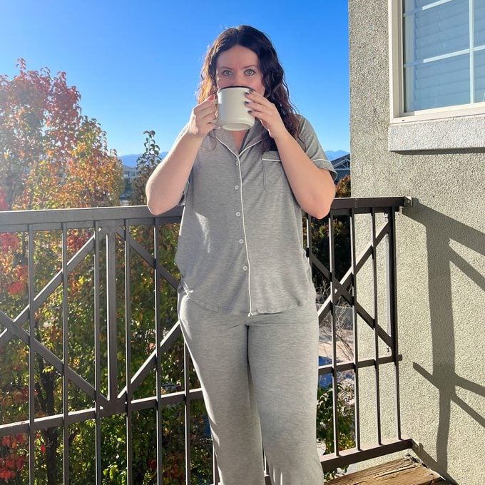 Madi drinking coffee on the balcony in Cozy Earth Bamboo Pajamas