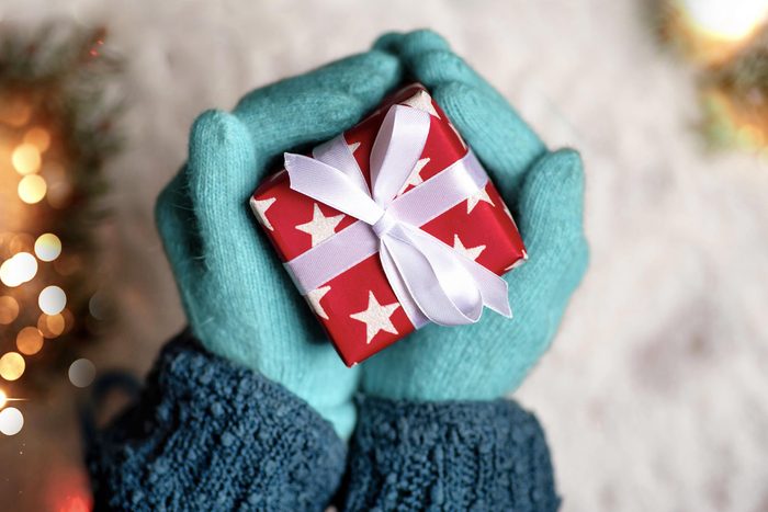 Gloved hands cradling a gift box