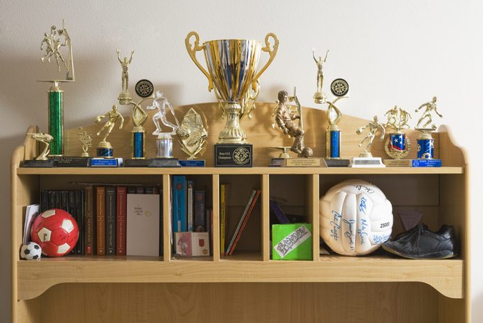 Sports trophies, balls and books on shelves