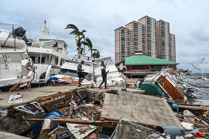 Residents inspect damage to a marina as boats are partially submerged in the aftermath of Hurricane Ian in Fort Myers, Florida, on September 29, 2022