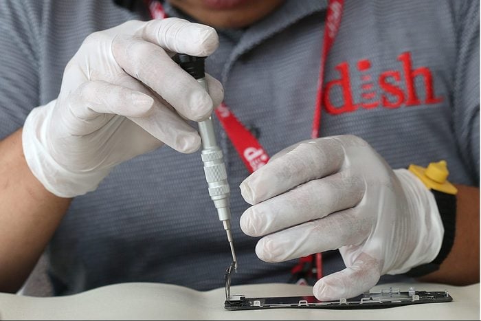 Dish employee Johnson Chuong takes apart an iPhone to fix a cracked screen on site in the Chronicle building in San Francisco, California, on wednesday, may 11, 2016.
