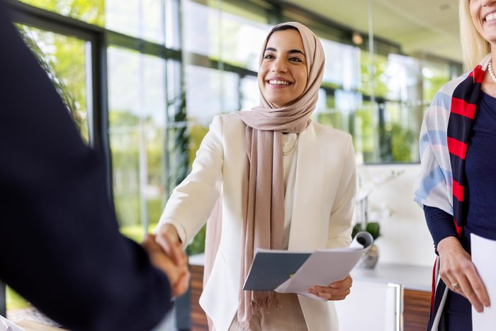 Muslim businesswomen sealing a deal with a handshake