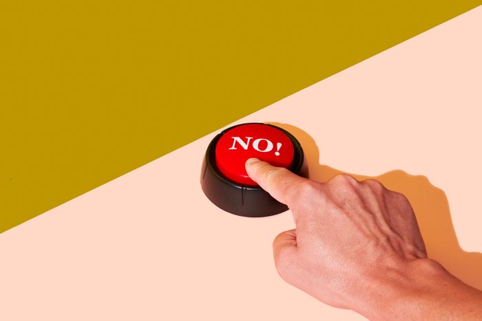 man pushing a red button with the word no