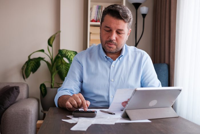 Man calculating personal expenses at home