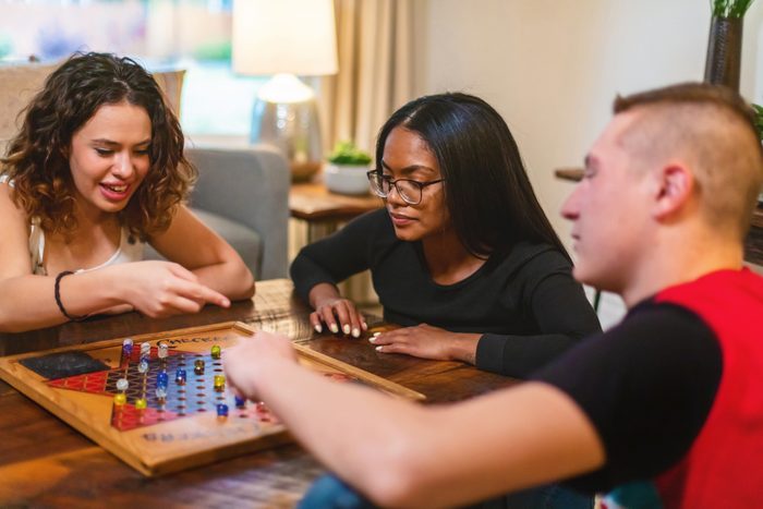 Generation Z Multiracial Group of Friends Cooking Playing Playing Chinese Checkers