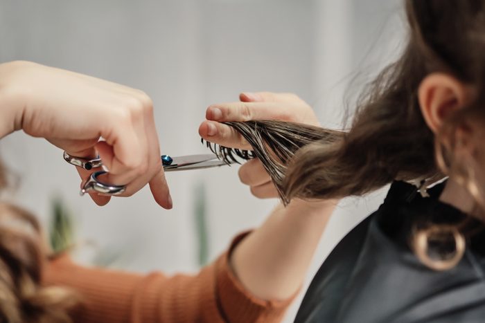 Human hands hair cut using a scissors lock of hair