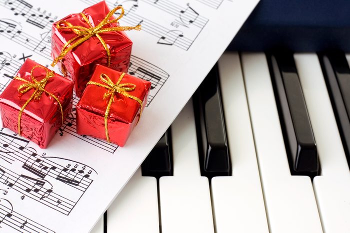 auld lang syne sheet music close up on piano keys with tiny christmas gifts