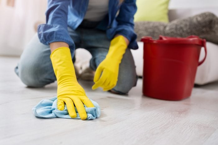 woman with gloves cleans the floor