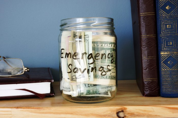 Jar with Emergency savings Cash Fund on the shelf.
