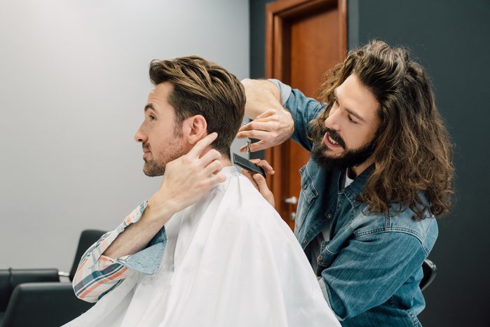 Man giving instructions to his hairdresser