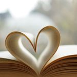 Heart from page of book for valentine's day concept with blurred bright light background and vintage tone