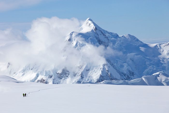 Two mountaineers are crossing a glacier on Mt. McKinley, Alaska. Mount Hunter is in the background.