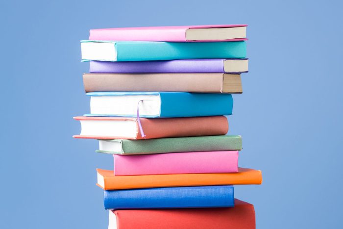 Stack Of Multi Colored Books On Blue Background